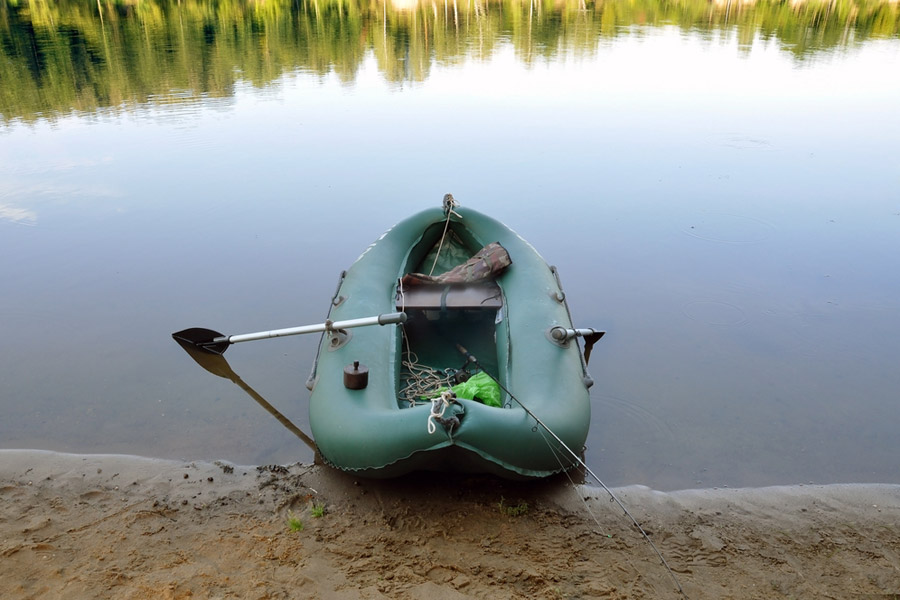 bateau de pêche gonflable amarré par le rivage sablonneux