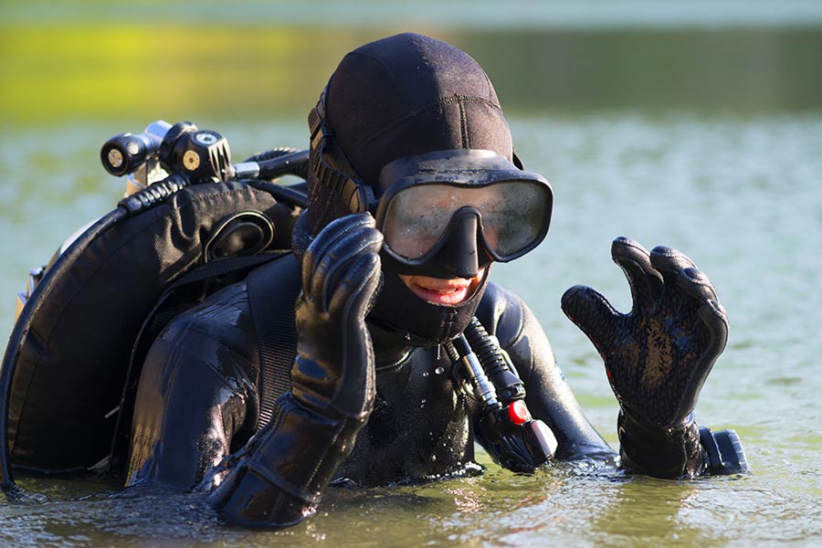 scuba diver emerging from water removing mask