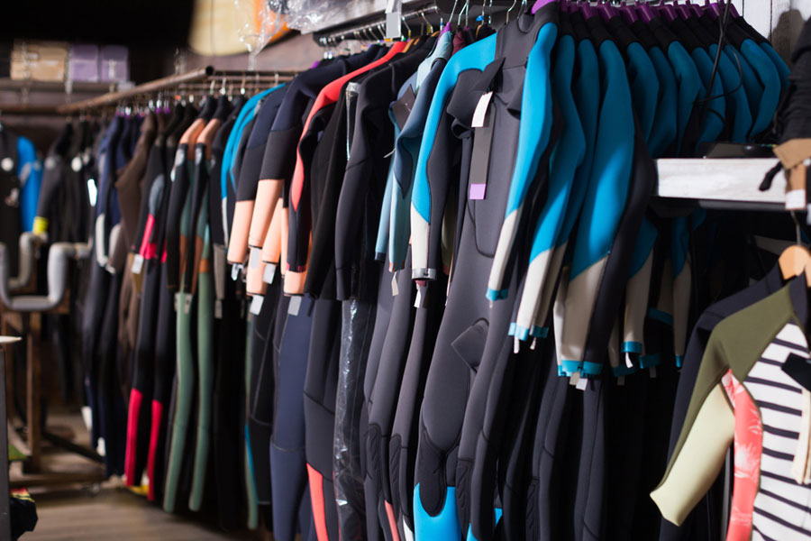 numerous wetsuits for sale in a store