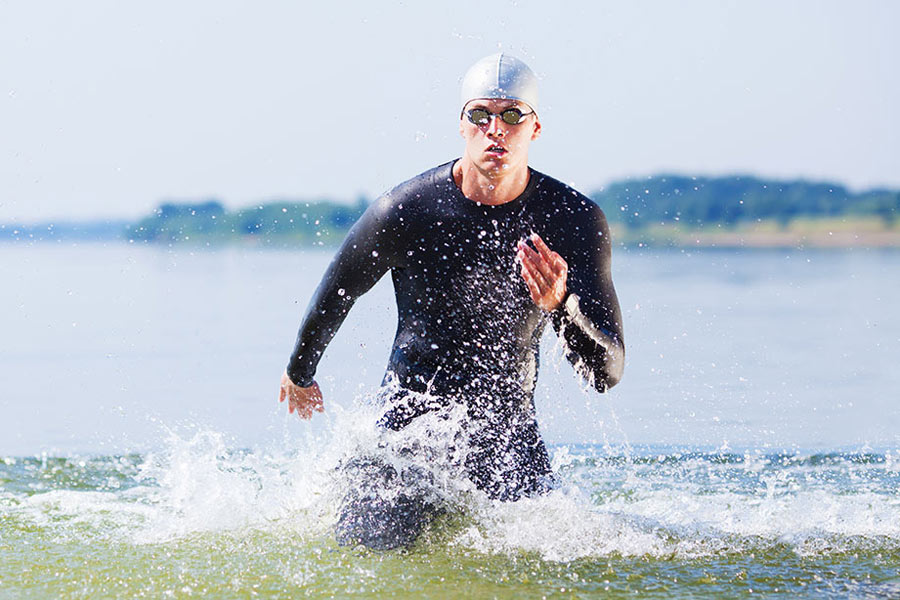 male triathlete getting out of the water