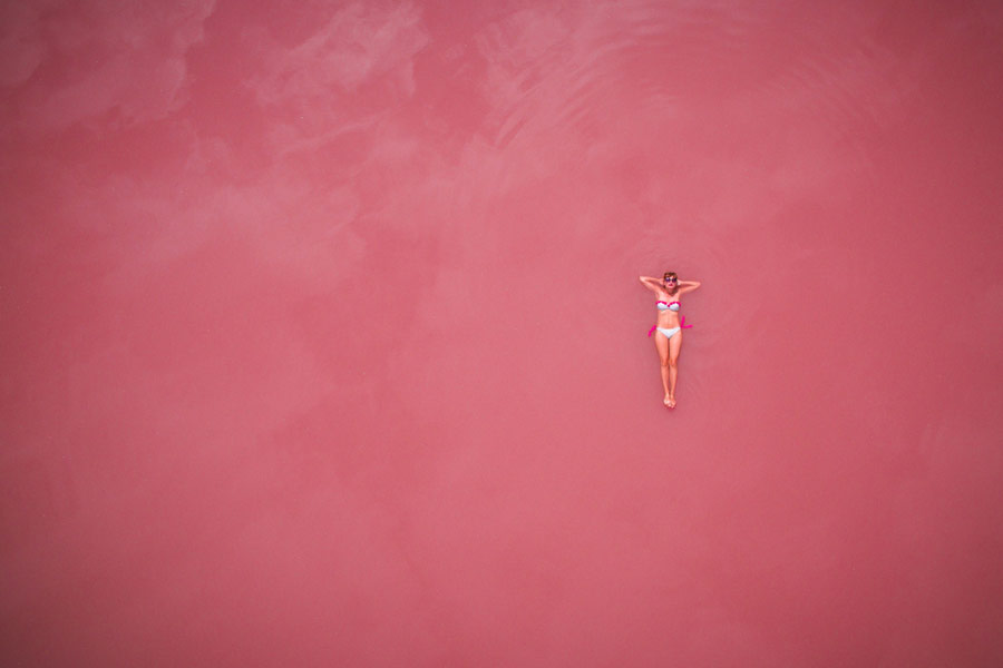 woman floating on top of a pink lake