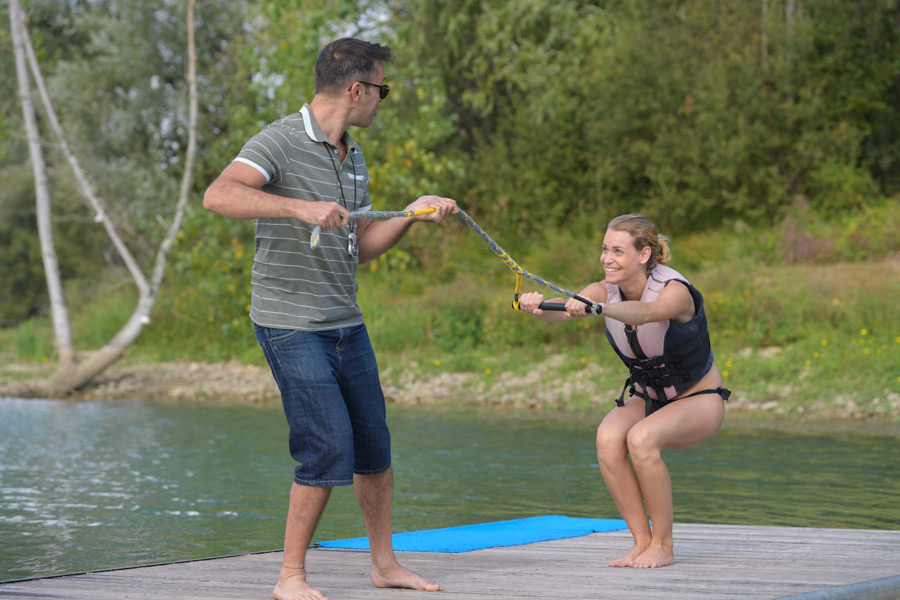 a water skiing instructor helping a woman practice on land