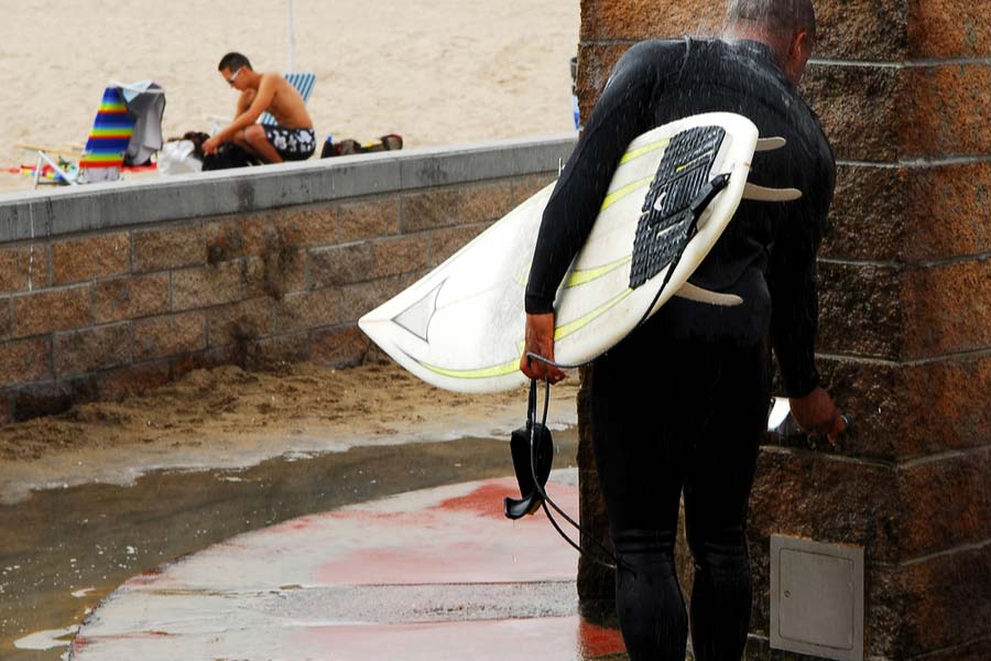 a male diver rinsing his wetsuit